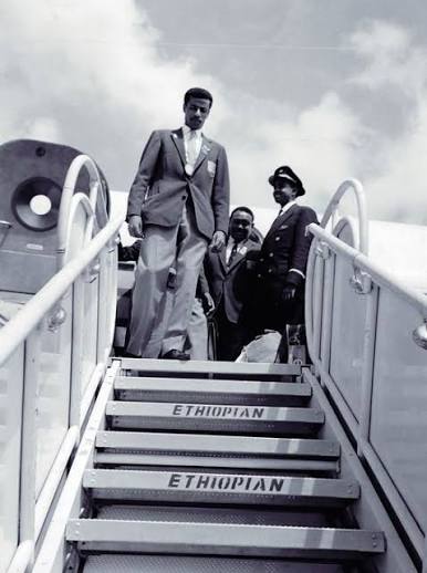 Abebe Bikila descending aircraft steps marked Ethiopian.
